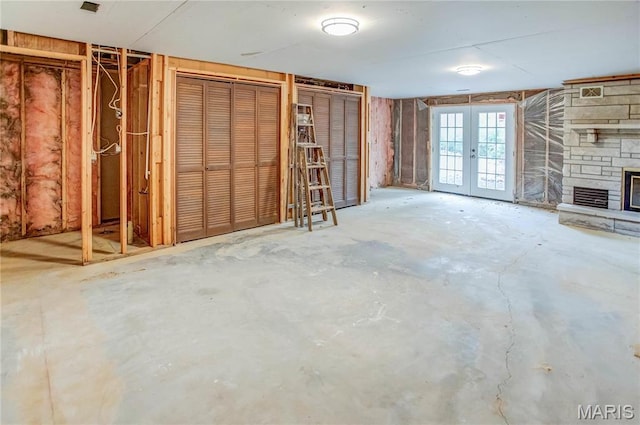 23388 Glenda Ave, Jerseyville, IL 62052 - unfurnished living room featuring french doors, a stone fireplace, and unfinished concrete floors
