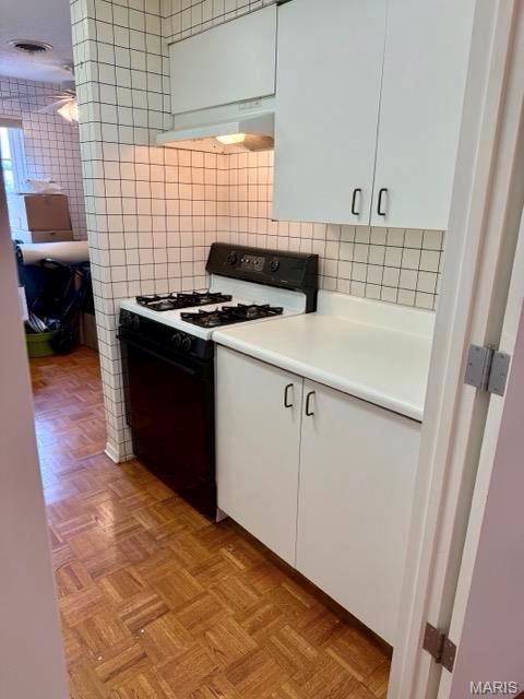 10367 Oxford Hill Dr Unit 26, Saint Louis, MO 63146 - kitchen featuring range with gas stovetop, under cabinet range hood, tile walls, white cabinetry, and light countertops