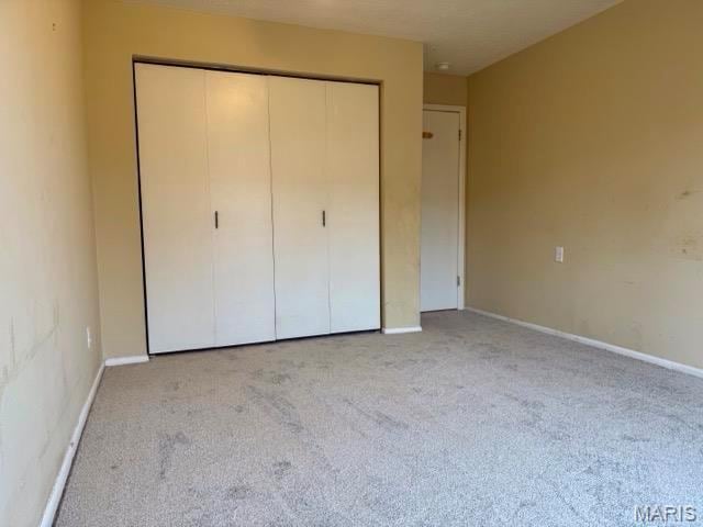 10367 Oxford Hill Dr Unit 26, Saint Louis, MO 63146 - unfurnished bedroom with a closet, light colored carpet, and baseboards