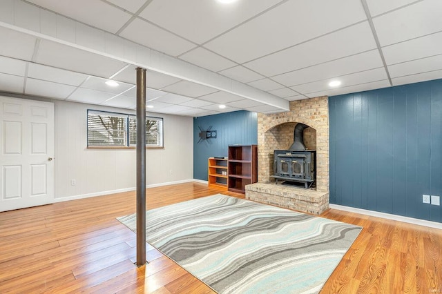 803 Fairview Dr, Washington, MO 63090 - living room featuring a wood stove, a paneled ceiling, baseboards, wood finished floors, and wooden walls