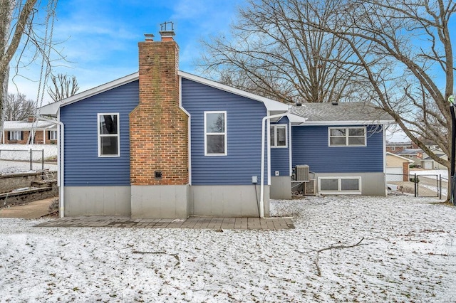 803 Fairview Dr, Washington, MO 63090 - snow covered property featuring fence, a chimney, central AC unit, and a gate