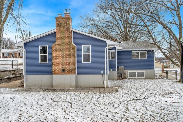 803 Fairview Dr, Washington, MO 63090 - snow covered back of property featuring a chimney, central AC, and a gate