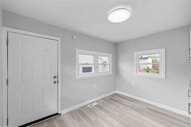 foyer featuring light wood-style floors and baseboards