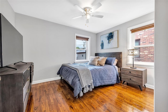bedroom featuring wood finished floors, baseboards, and a ceiling fan