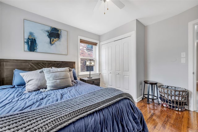 bedroom with a closet, wood finished floors, ceiling fan, and baseboards