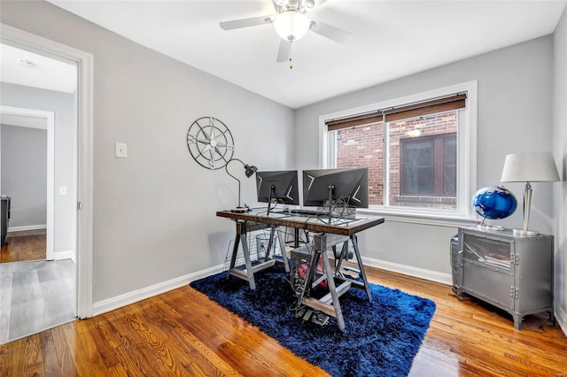 office area featuring a ceiling fan, wood finished floors, and baseboards