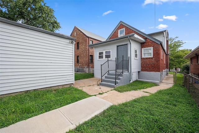 view of front facade featuring brick siding, a gate, and cooling unit
