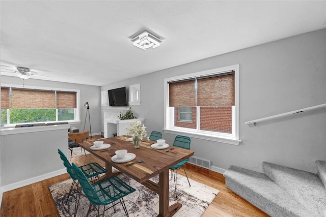 dining area with a ceiling fan, baseboards, light wood-style flooring, and stairs