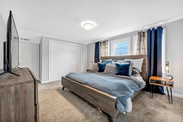 bedroom featuring light colored carpet, a closet, and baseboards