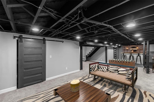 living area with carpet flooring, baseboards, a barn door, and stairs