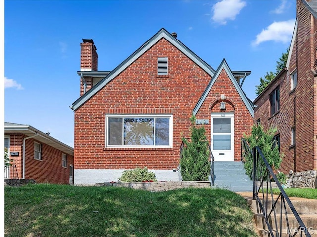 3621 Watson Rd, Saint Louis, MO 63109 - tudor home with brick siding, a chimney, and a front lawn