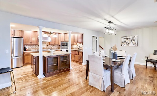 dining area with light wood-style floors and baseboards