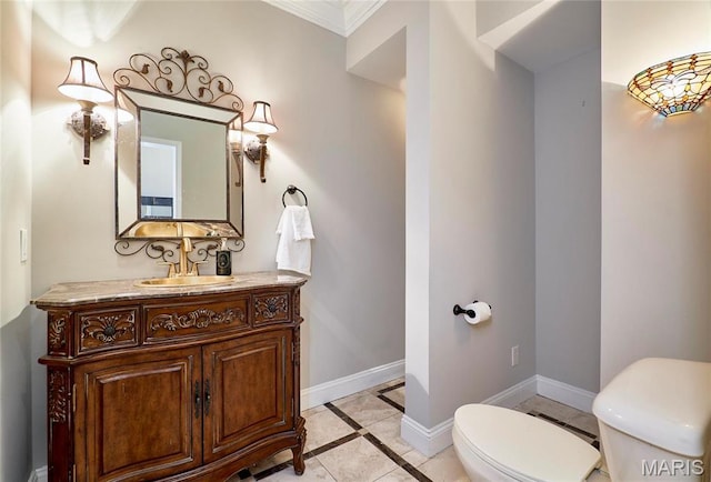 bathroom with toilet, baseboards, ornamental molding, vanity, and inlaid floor details