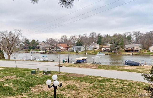 view of yard featuring a residential view and a water view