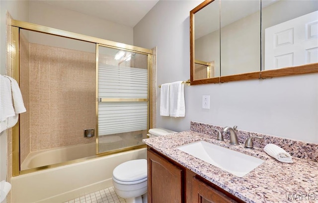 bathroom featuring toilet, bath / shower combo with glass door, vanity, and tile patterned flooring