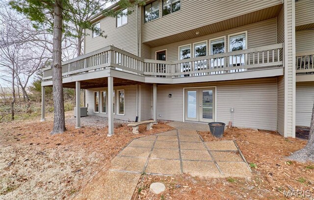 rear view of house with a wooden deck, french doors, a patio, and central AC unit