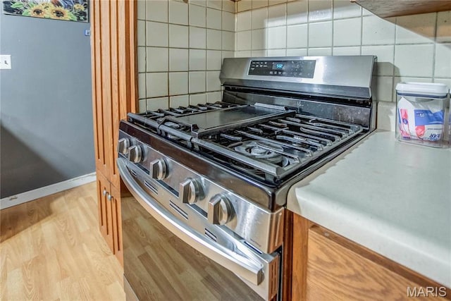 121 Douglas Dr, Pleasant Hill, IL 62366 - kitchen view of stainless steel range with gas stovetop, tasteful backsplash, light wood finished floors, and baseboards