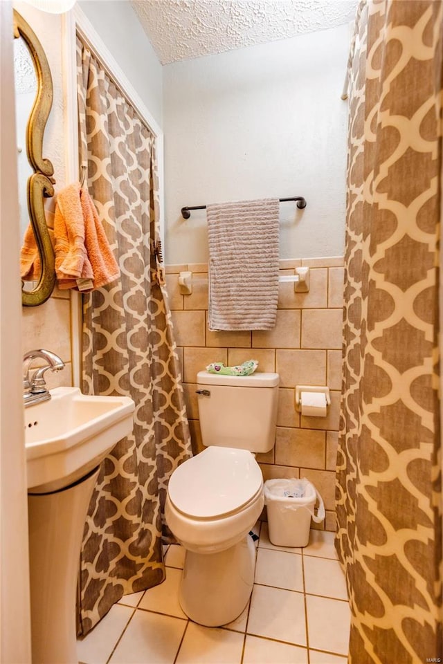 1040 N Kingshighway, Sikeston, MO 63801 - bathroom featuring tile patterned floors, toilet, a textured ceiling, wainscoting, and a sink