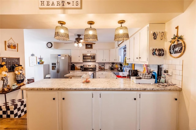 1040 N Kingshighway, Sikeston, MO 63801 - kitchen with appliances with stainless steel finishes, a peninsula, backsplash, a ceiling fan, and white cabinets