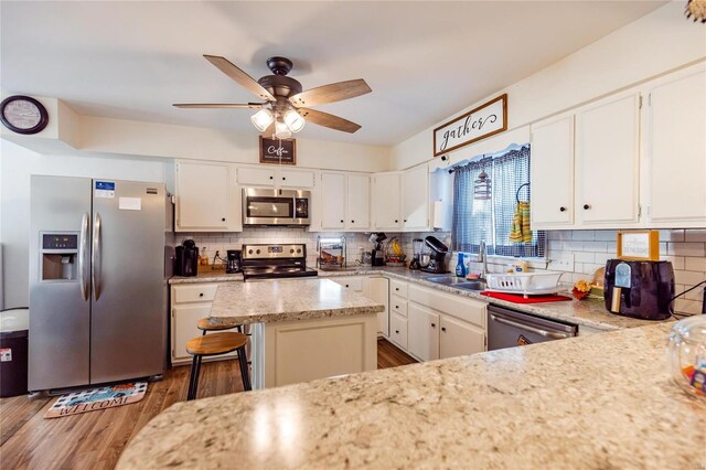 1040 N Kingshighway, Sikeston, MO 63801 - kitchen featuring stainless steel appliances, a sink, backsplash, a ceiling fan, and white cabinets
