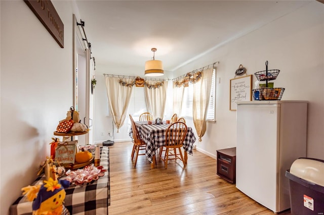 1040 N Kingshighway, Sikeston, MO 63801 - dining room featuring a barn door, light wood finished floors, and baseboards