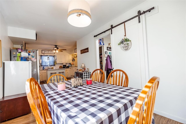 1040 N Kingshighway, Sikeston, MO 63801 - dining room with a barn door, light wood finished floors, and ceiling fan
