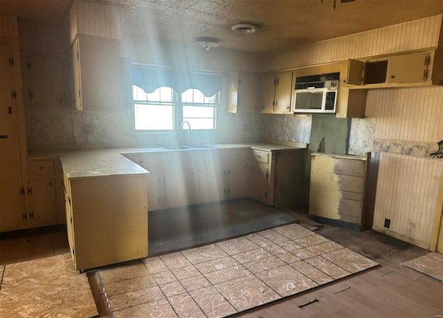 206 Chance St, Kennett, MO 63857 - kitchen featuring light wood-style flooring, light countertops, a sink, and tasteful backsplash