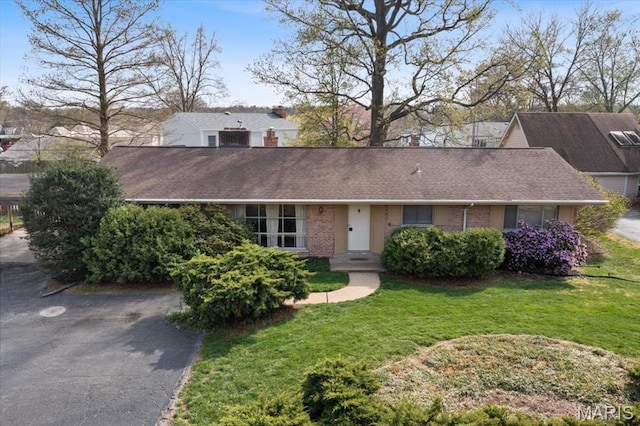 single story home featuring a front lawn and brick siding