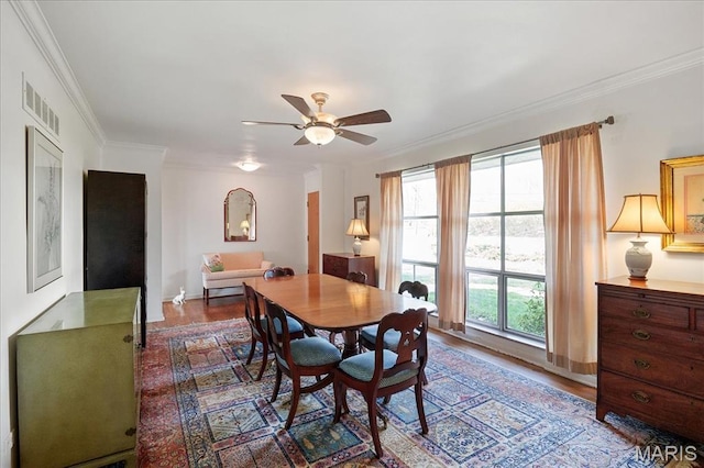 dining space featuring a ceiling fan, wood finished floors, ornamental molding, and baseboards
