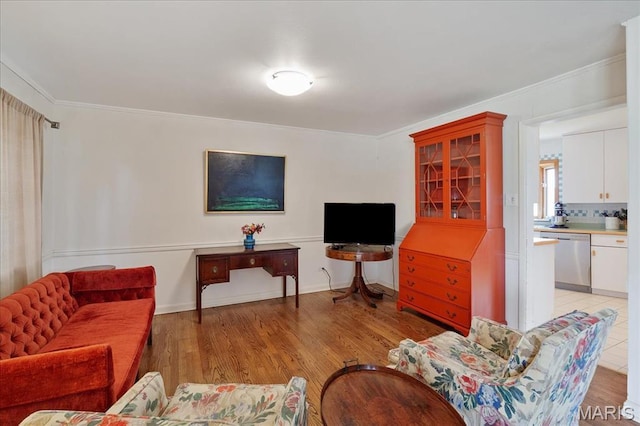 living area featuring crown molding and light wood finished floors