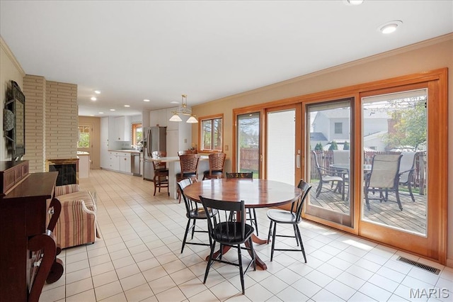 dining space featuring light tile patterned floors, crown molding, and recessed lighting
