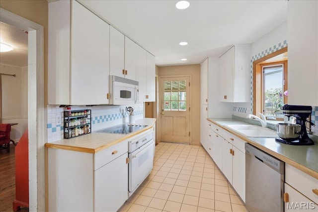 kitchen featuring white appliances, light countertops, decorative backsplash, white cabinetry, and recessed lighting
