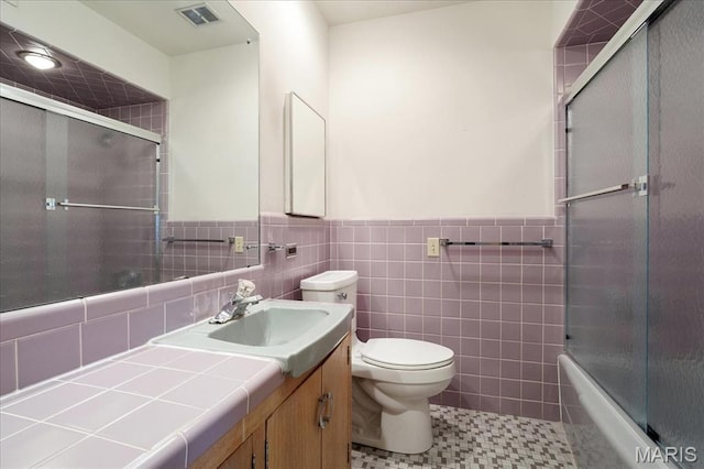 full bathroom featuring toilet, a wainscoted wall, and vanity