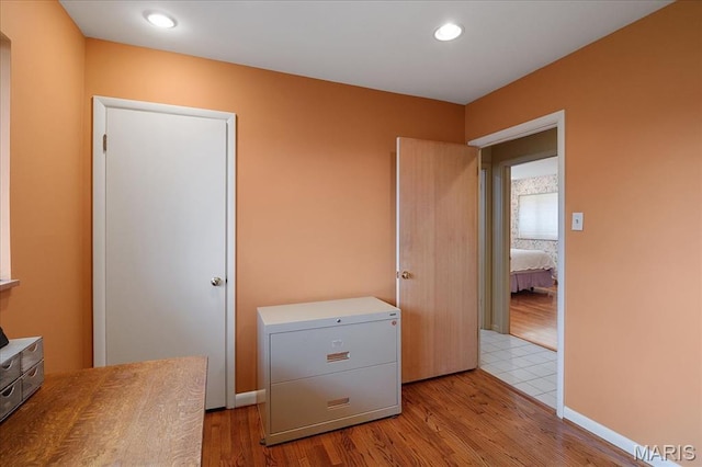 clothes washing area featuring wood finished floors and recessed lighting