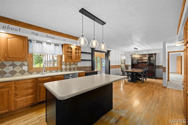 15020 Jamestown Rd, Breese, IL 62230 - kitchen with brown cabinetry, light countertops, stainless steel dishwasher, a textured ceiling, and wainscoting