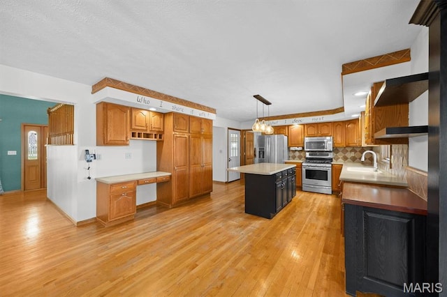 15020 Jamestown Rd, Breese, IL 62230 - kitchen with appliances with stainless steel finishes, a kitchen island, light wood-type flooring, light countertops, and brown cabinets