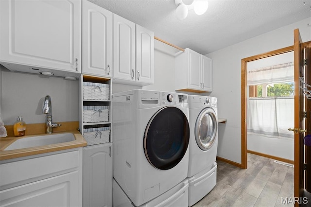 15020 Jamestown Rd, Breese, IL 62230 - laundry area with washing machine and clothes dryer, cabinet space, light wood finished floors, and a textured ceiling