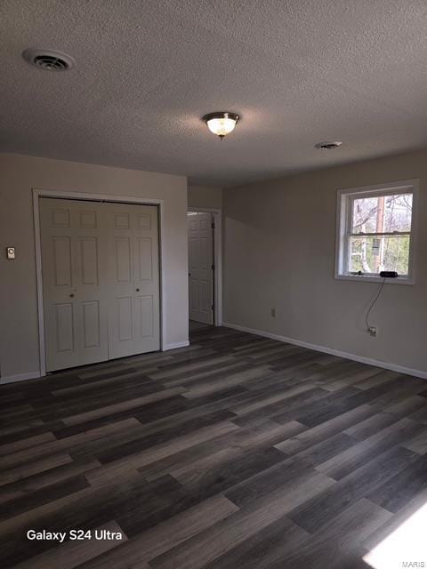 15020 Hackney Dr, Saint Robert, MO 65584 - unfurnished bedroom with baseboards, a textured ceiling, a closet, and dark wood finished floors