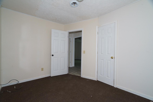 15020 Hackney Dr, Saint Robert, MO 65584 - unfurnished bedroom featuring a textured ceiling, dark carpet, and baseboards