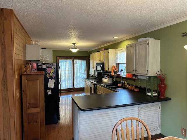 25 Whispering Oaks Dr, Washington, MO 63090 - kitchen with black appliances, a textured ceiling, dark countertops, crown molding, and a peninsula