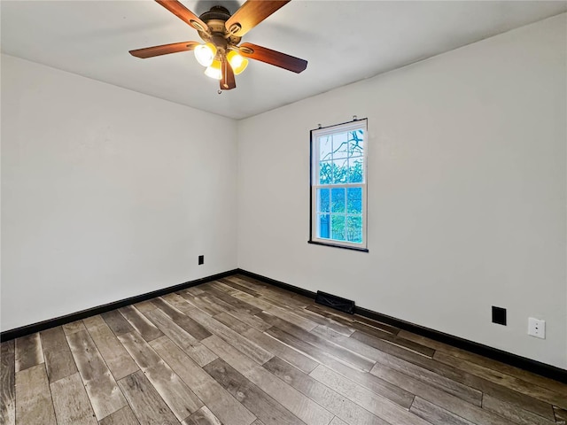 empty room with wood finished floors, ceiling fan, and baseboards