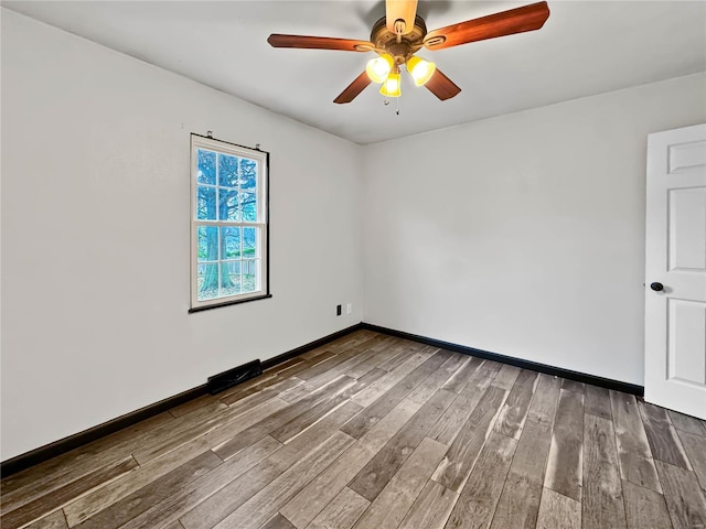 spare room featuring wood finished floors, ceiling fan, and baseboards