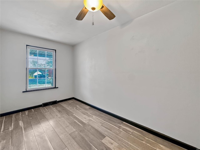 empty room with light wood finished floors, ceiling fan, and baseboards
