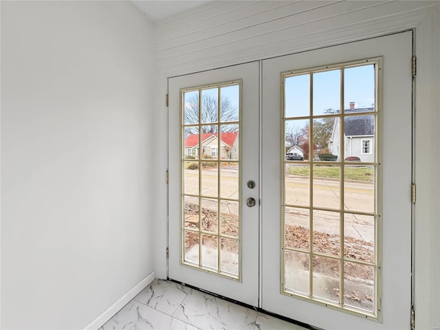 doorway with french doors, light marble finish floors, and baseboards