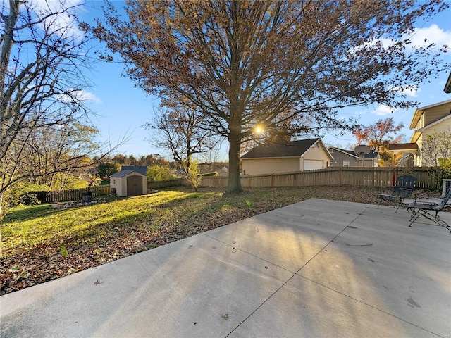view of patio with a storage unit, a fenced backyard, and an outbuilding
