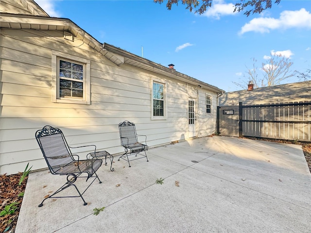 view of patio featuring fence and a gate