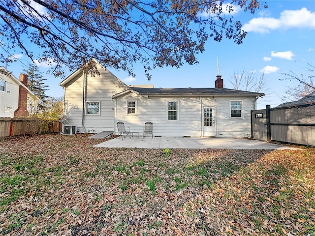 back of property featuring a patio, a fenced backyard, central AC, and a chimney