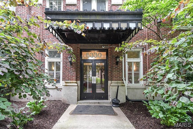 entrance to property featuring french doors and brick siding