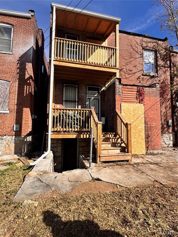 3936 Lexington Ave, Saint Louis, MO 63107 - rear view of property with a balcony, a porch, and brick siding