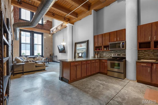 1113 Washington Ave Unit 215, Saint Louis, MO 63101 - kitchen with appliances with stainless steel finishes, a high ceiling, finished concrete flooring, a wooden ceiling with exposed beams, and decorative columns